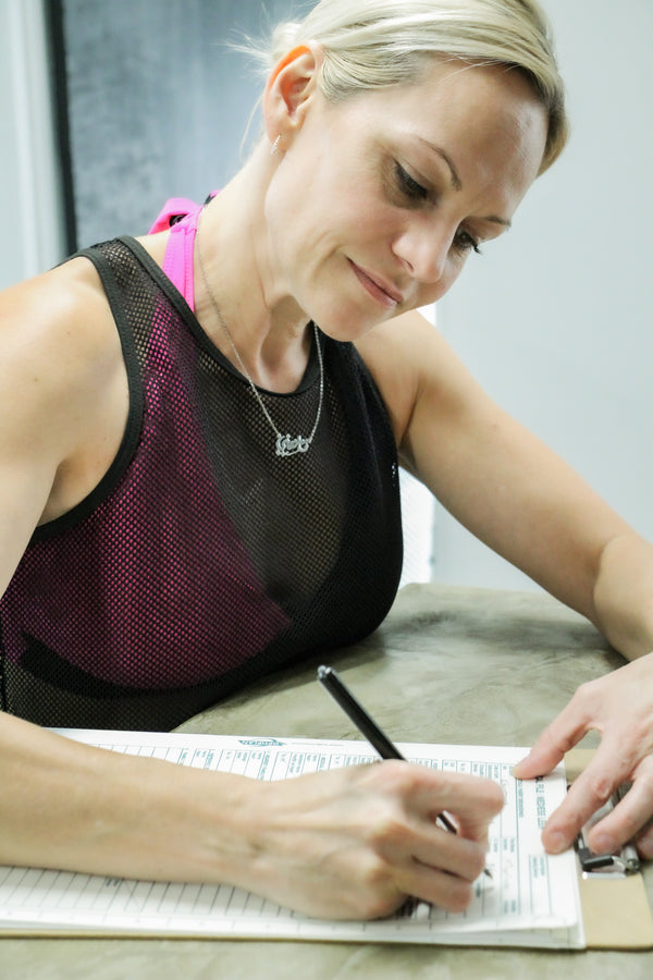 Woman filling in her Fitberi Wellness forms at the Fitberi Wellness reception desk in Pretoria.