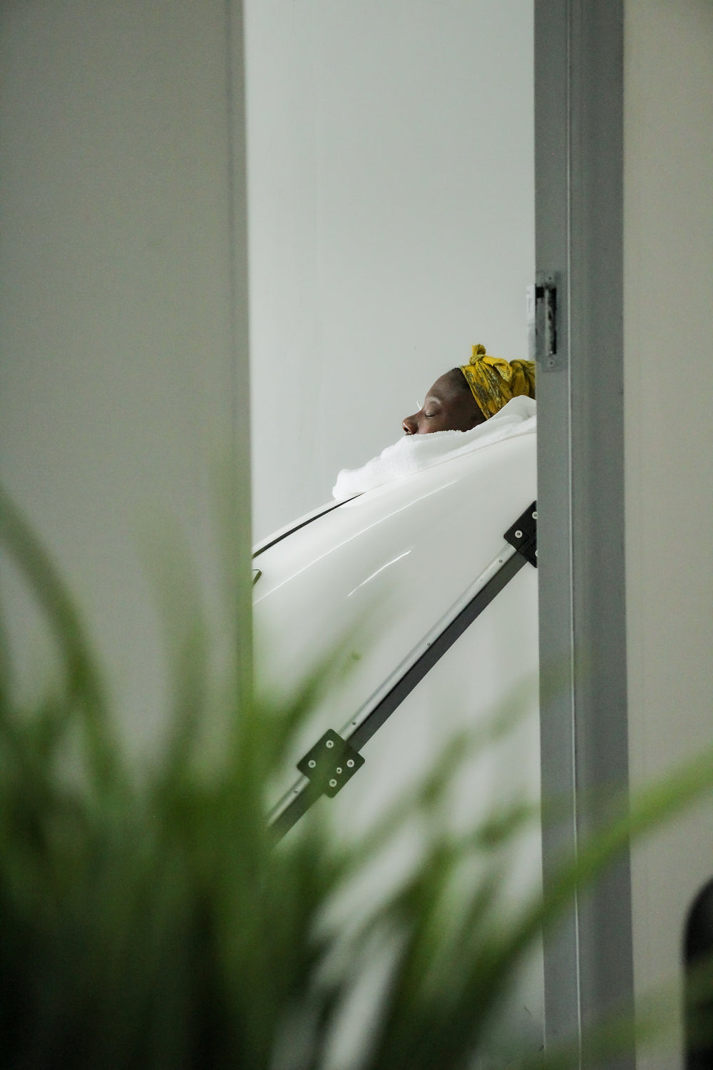 Person sitting in an ozone capsule with a plant in the foreground