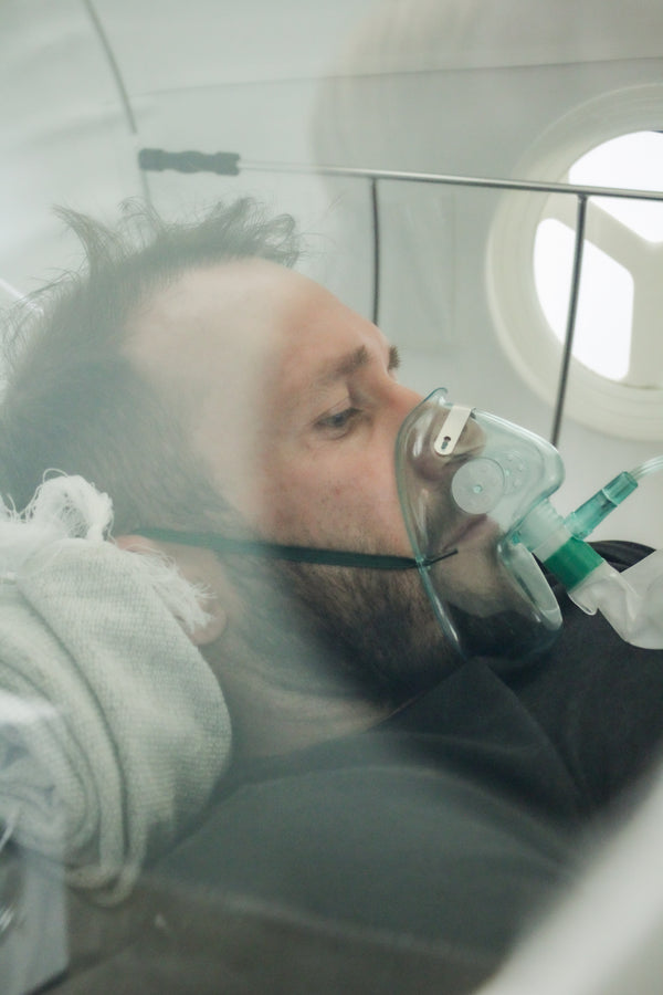 Pieter Smith lying in the MHBOT at Fitberi Wellness in Pretoria with an oxygen mask on.